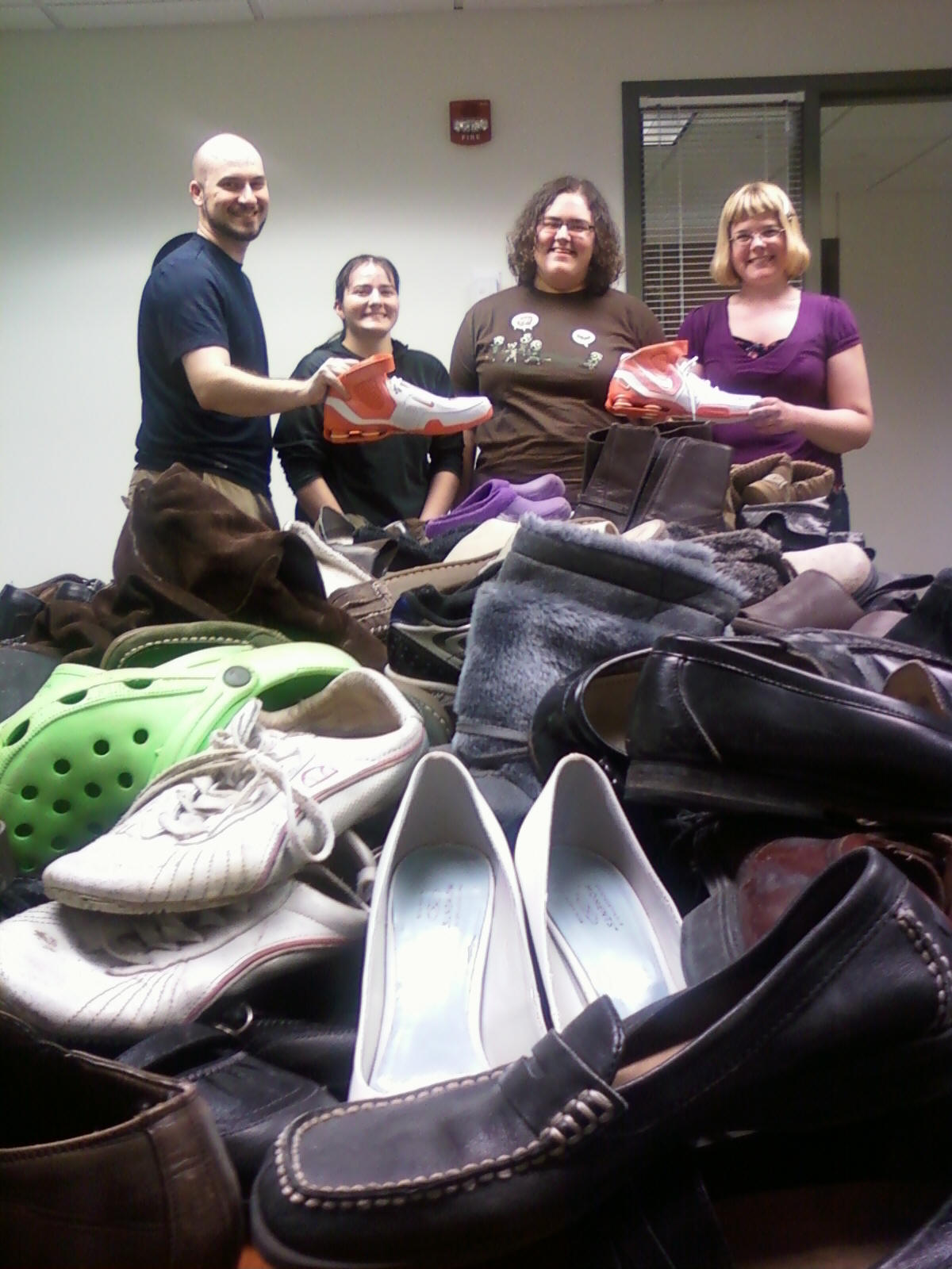 Pi Gamma Mu students with pile of shoes