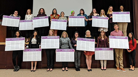 students holding large posters