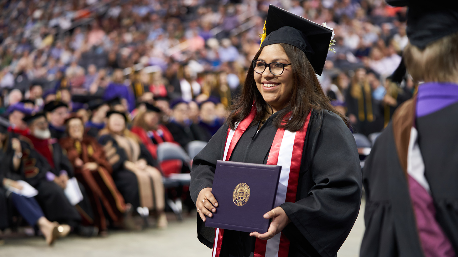 UE graduate with diploma at commencement