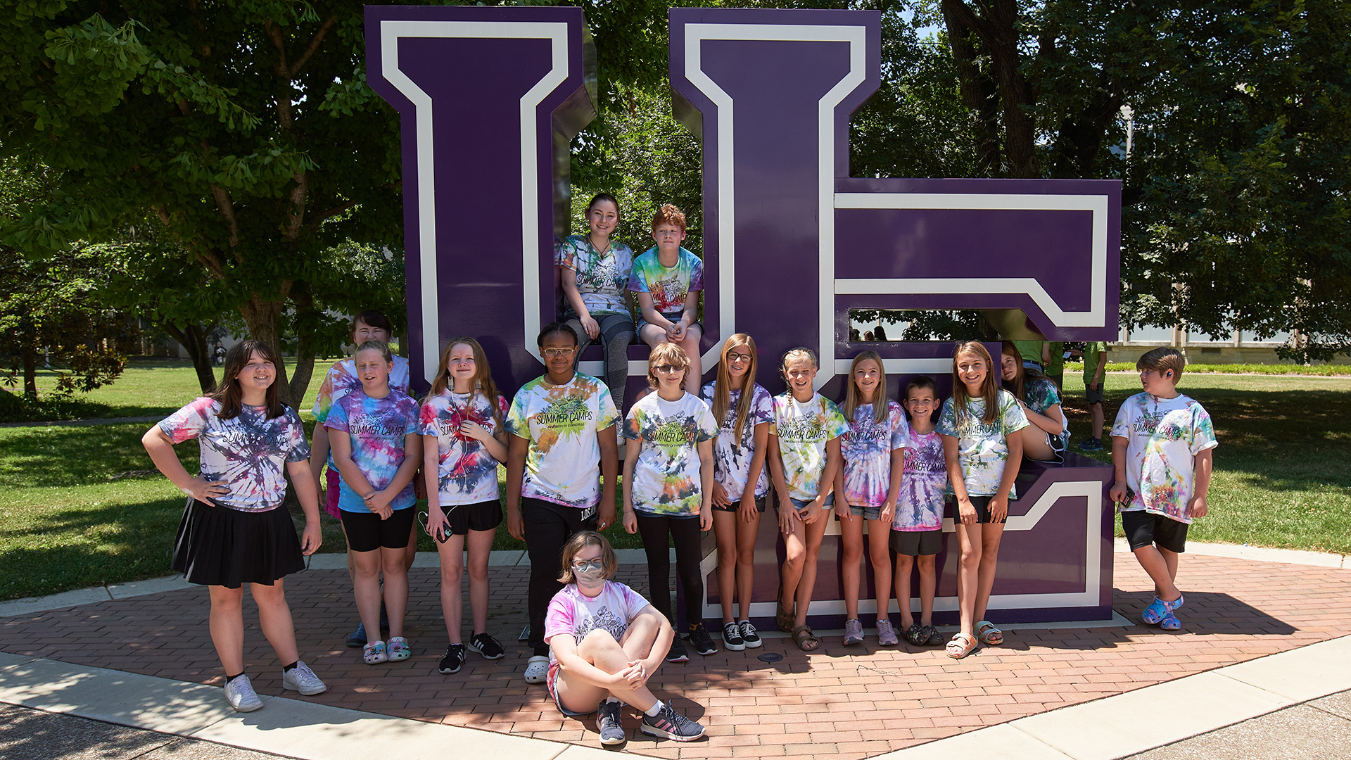 Art Camp students in front of UE letters sign