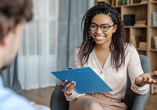 Life coach in counseling session with clipboard
