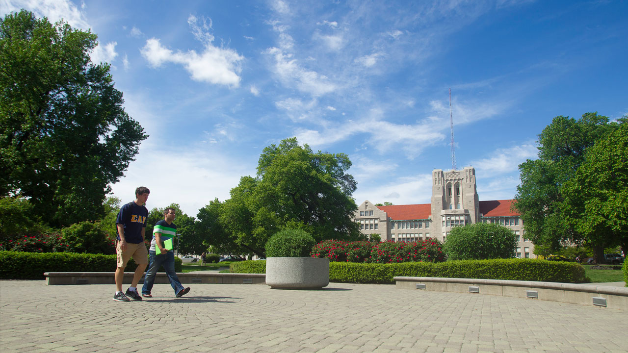 Two students walking across campus