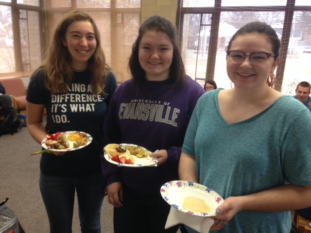 Three female students enjoy food and camaraderie at the Honors Breakfast Club.