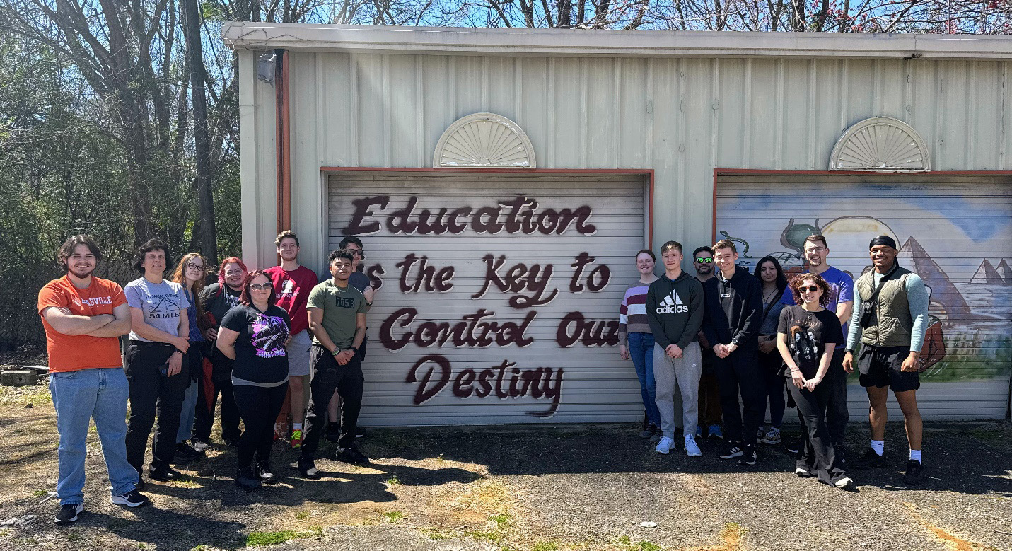 Students in front of a decorated garage door that says Education is the key to control our destiny