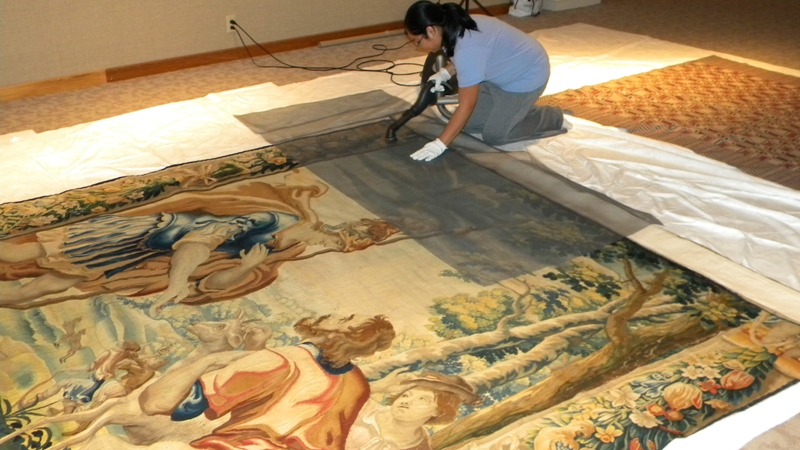 UE student restoring a large tapestry