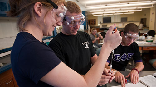 B-to-MD students in lab with safety glasses on.