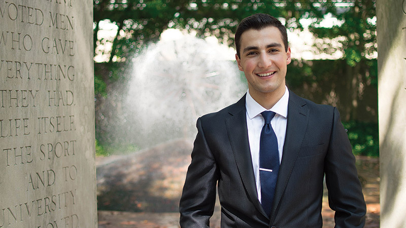 Business student in suit in front of fountain