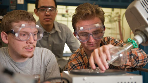 Chemistry students in lab pouring