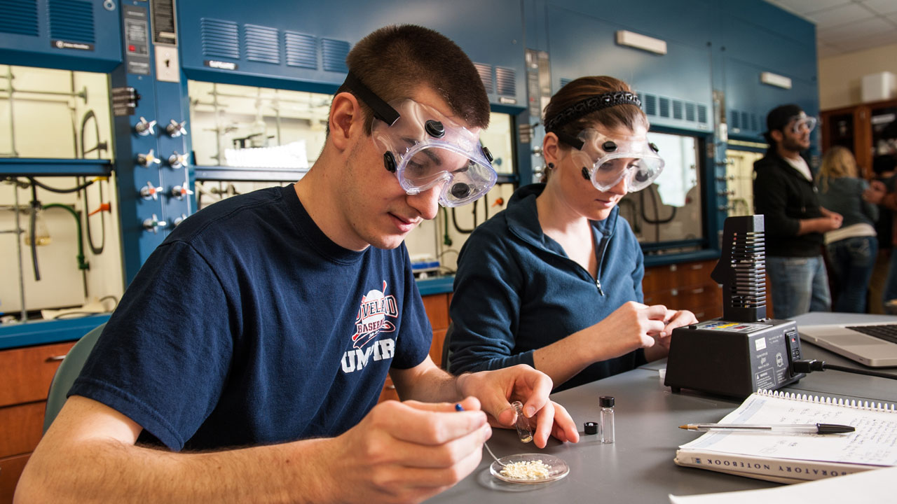 Chemistry students in lab wearing protective goggles.