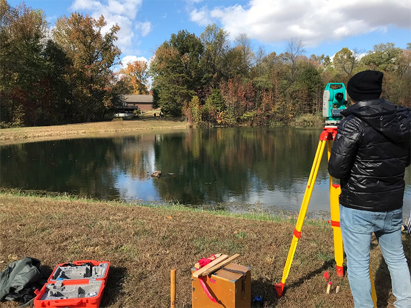 Civil Engineering student surveying Hall Lake Dam
