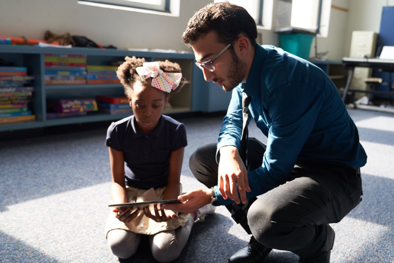 Student with child holding iPad