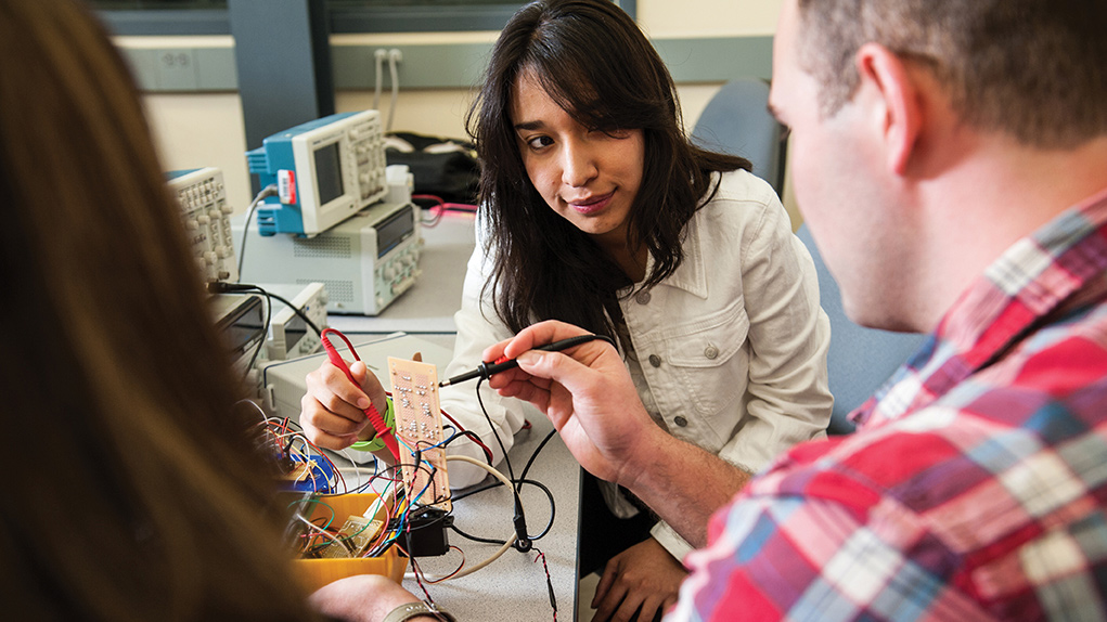 Engineering students testing circuit board