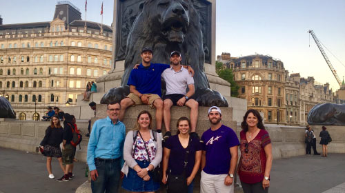 Students abroad in front of statue of a lion