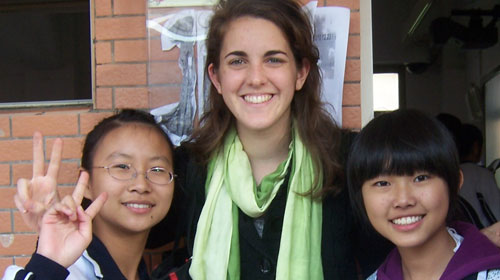 Three international students giving peace signs.