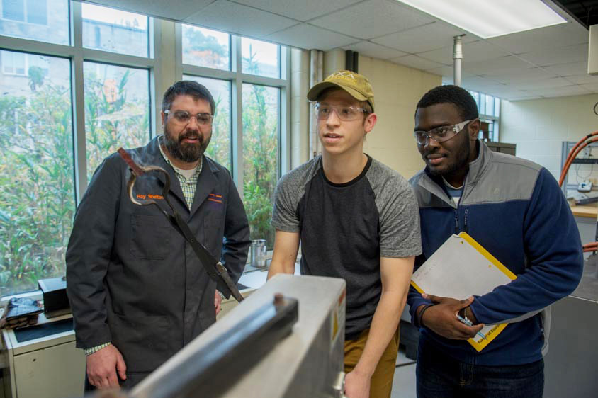 Students and professor work on lab project
