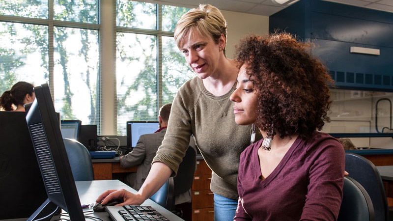 Lora Becker helping student at computer