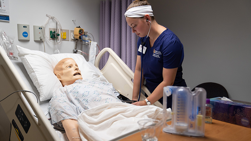 Nursing lab student with dummy