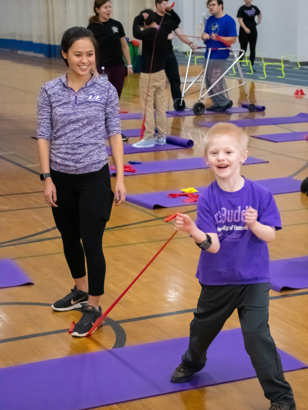 AceBuddy volunteer with child stretching cord