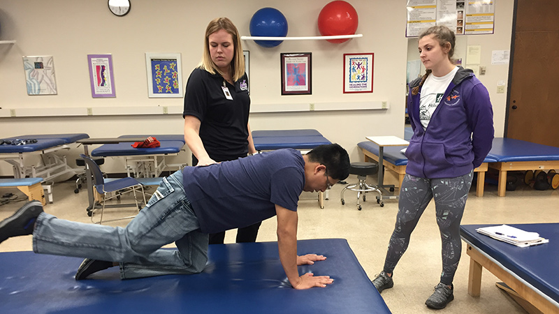 Two Ace CARE students with patient stretching