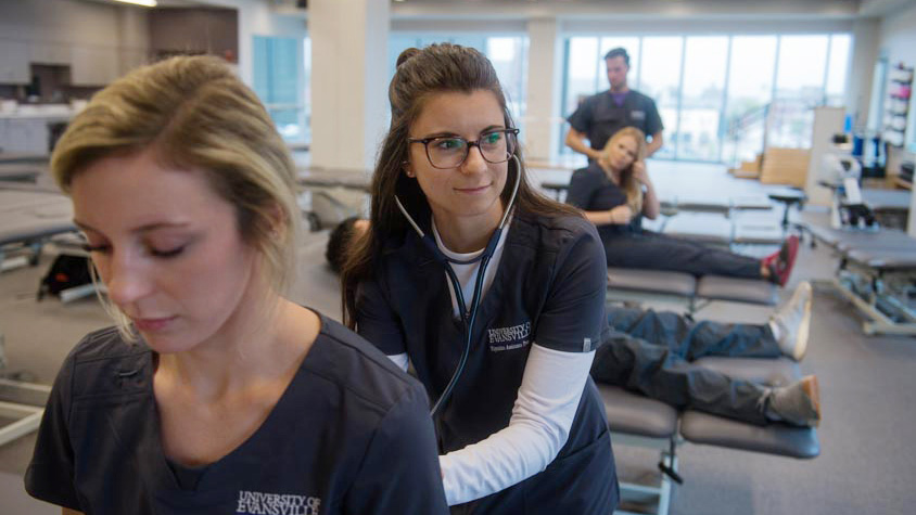 PA student in glasses using stethoscope