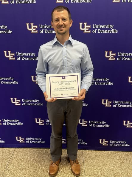 Dr. Aleks Nagornay holding award
