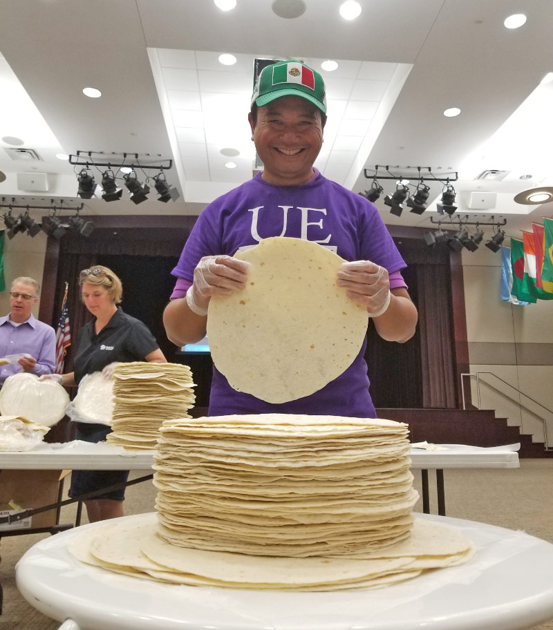 Mark Valenzuela standing in front of a stack of tortillas.