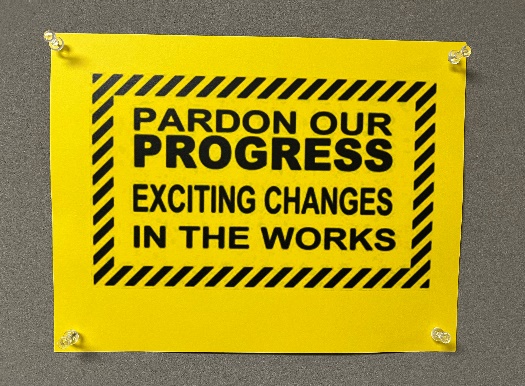 Pardon Our Progress yellow sign.