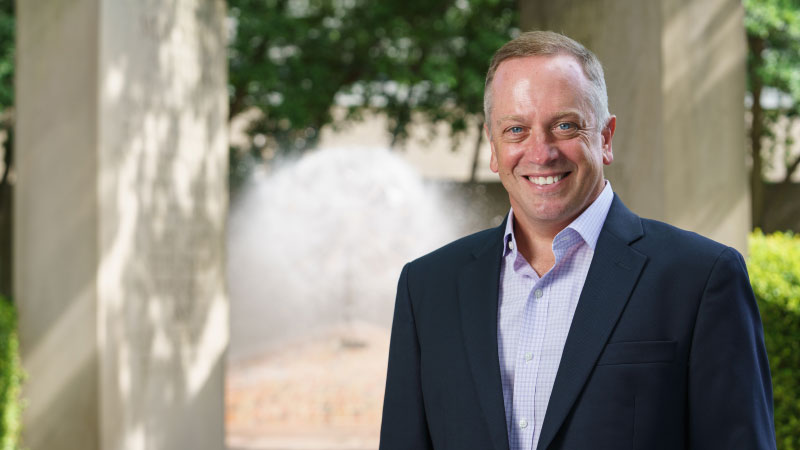 President Christopher M. Pietruszkiewicz standing in front of the Weeping Basketball Fountain