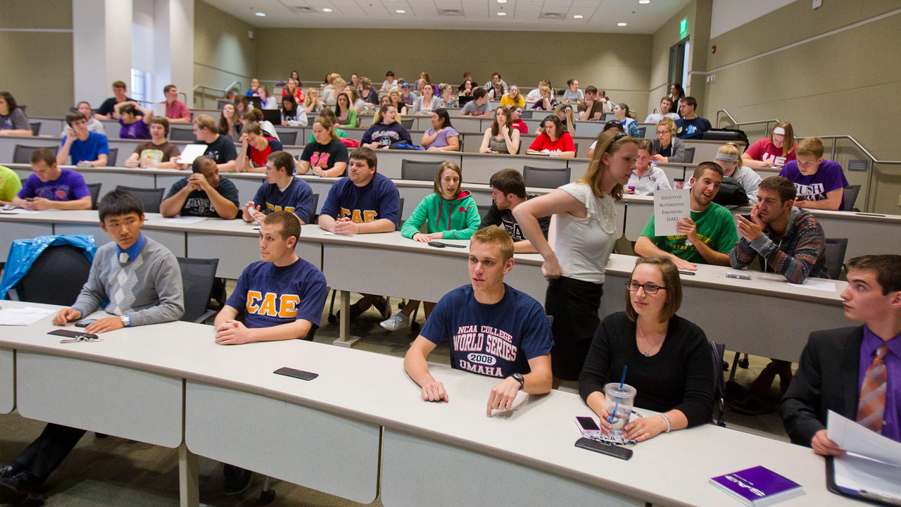 UE students prepare to listen to a lecture in an auditorium style classroom