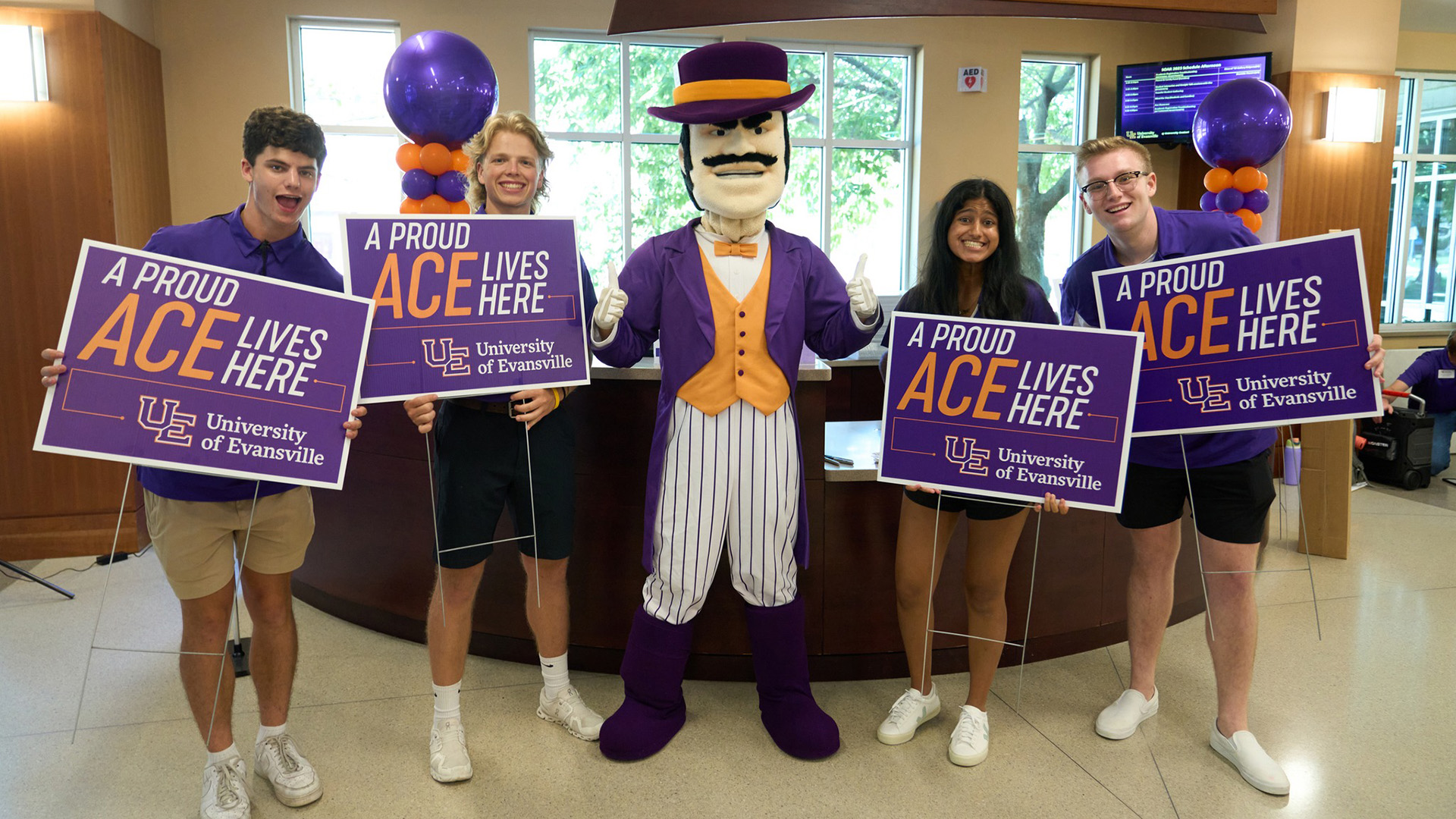 Ace Purple with students holding signs that say A Proud Ace Lives Here