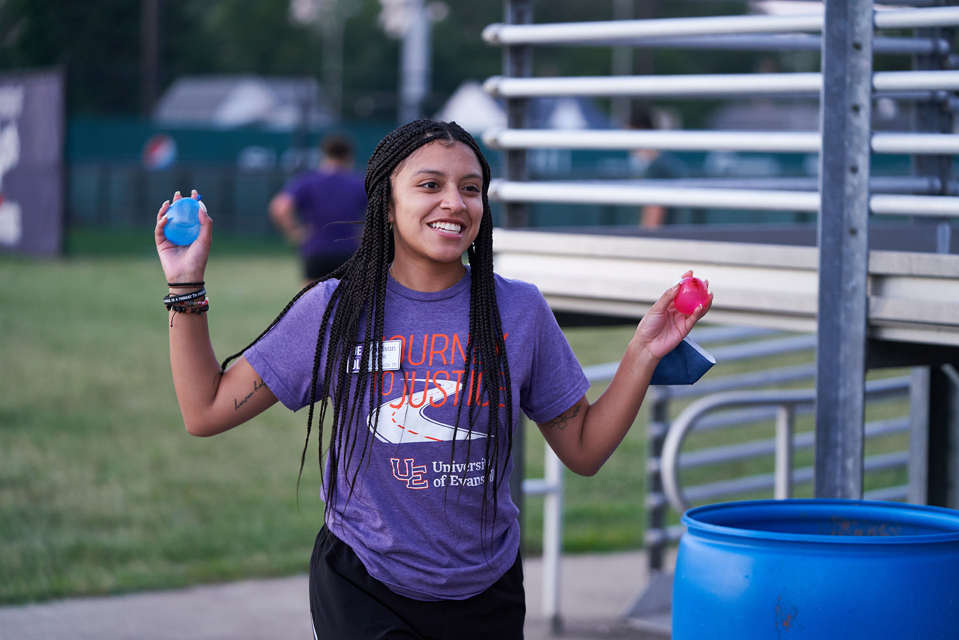 Welcome Week student holding water balloons.