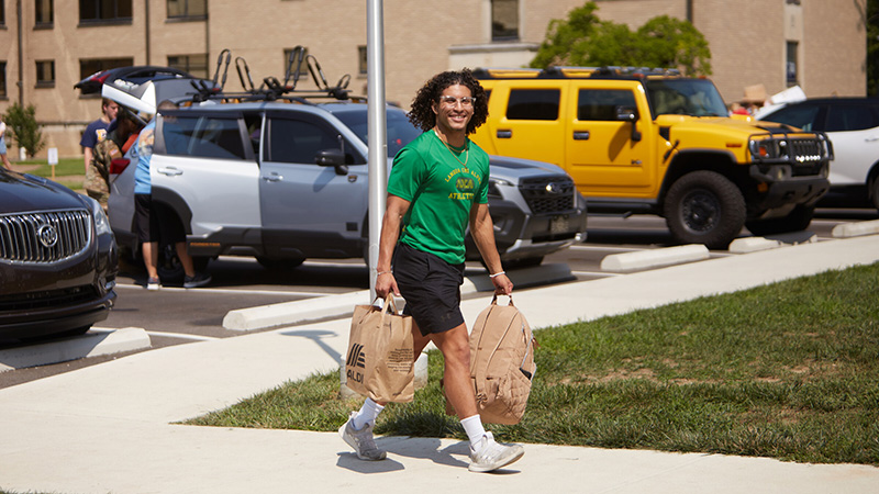 Student bring groceries in from parking lot