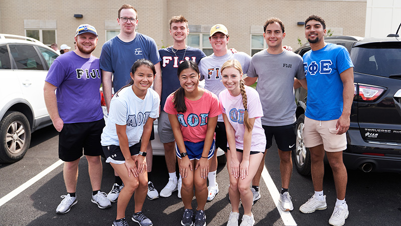 Fraternities Sororities members in shirts with logos for each