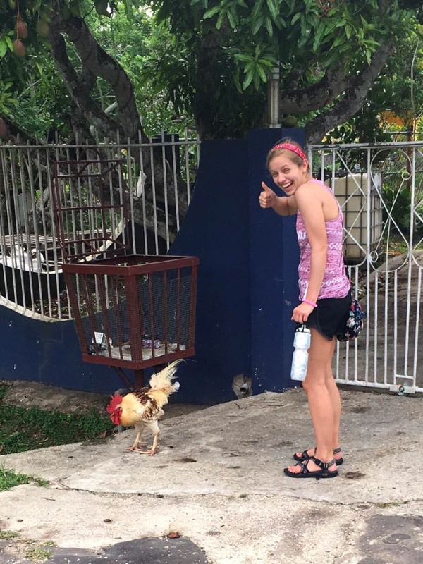 Melinda giving a thumbs up next to a chicken.