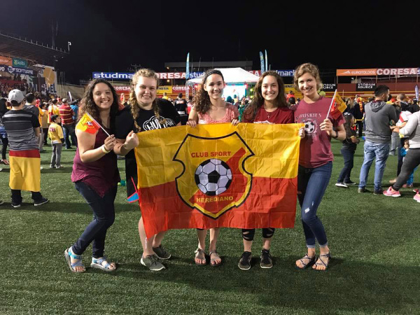 Natalie and friends holding up a flag