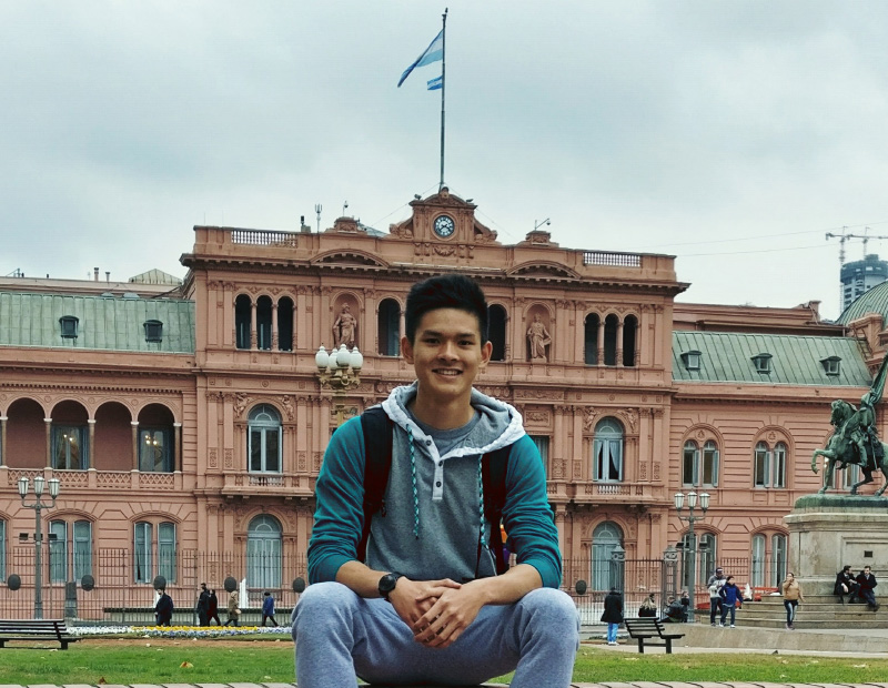 Toan sitting in front of a famous building