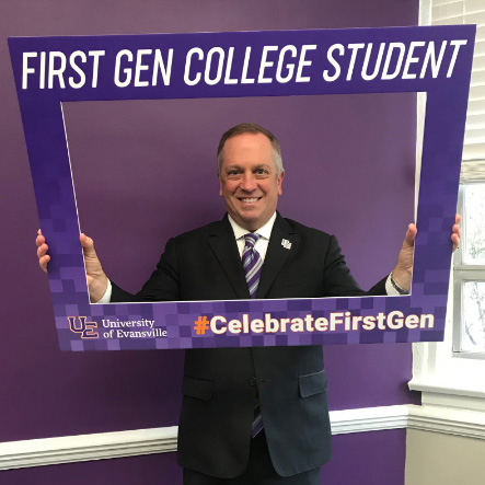 Prez P holding a sign that say First Gen Student