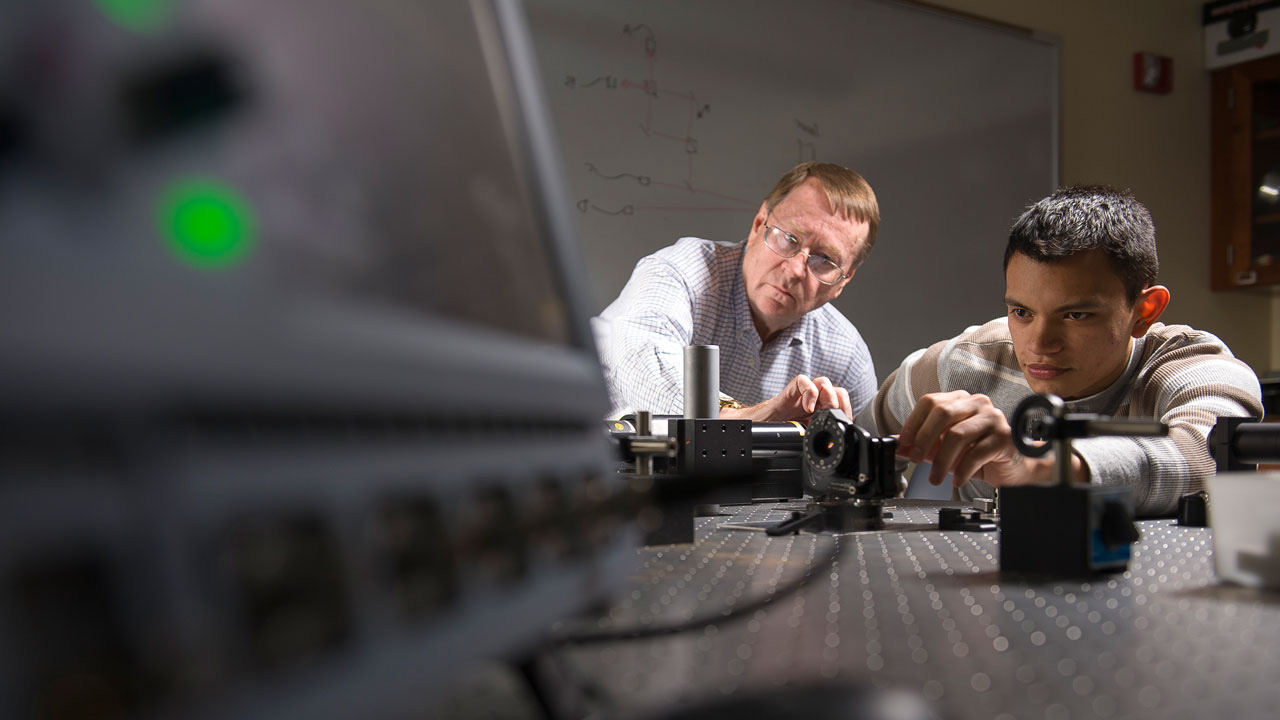 Engineering student and faculty in lab with laser