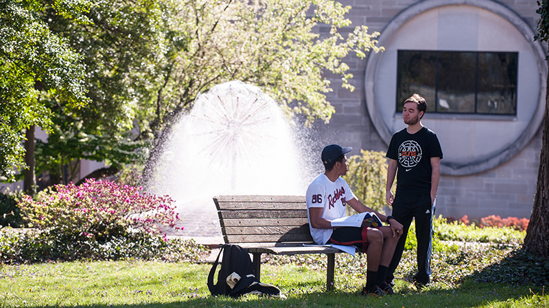 Students on bench near fountain in Summer.