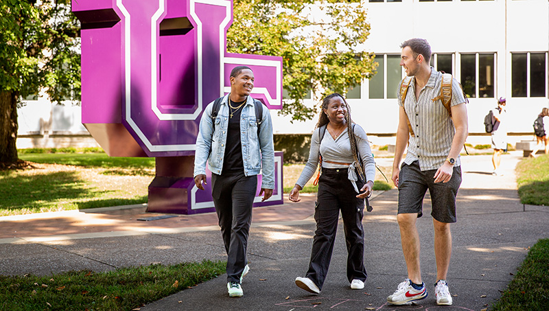 Students walking past UE letters