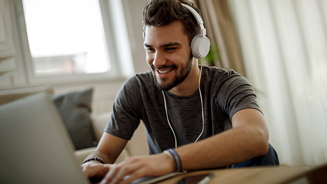 Student wearing headphones on laptop