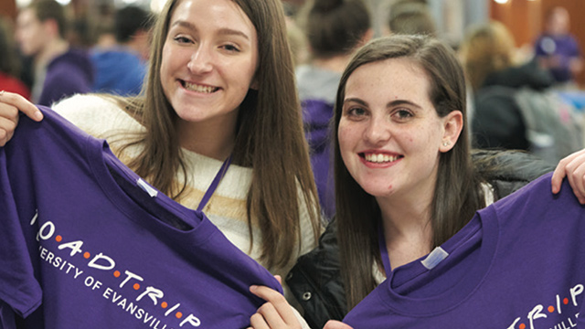 Students holding up Road Trip t-shirts